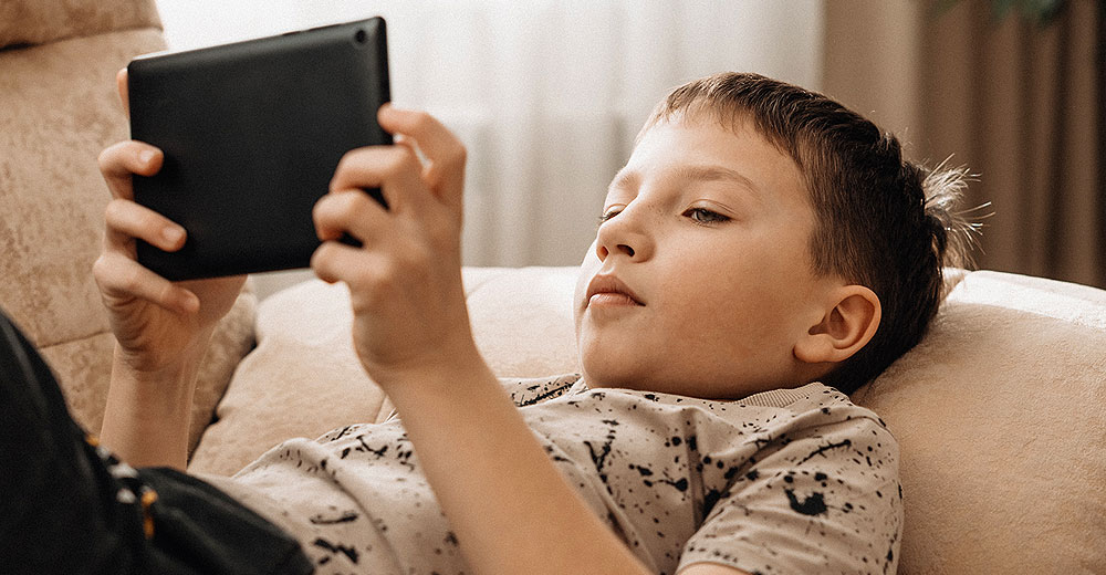 teenage boy reading tablet