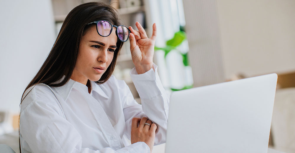 businesswoman at desk reading on a computer